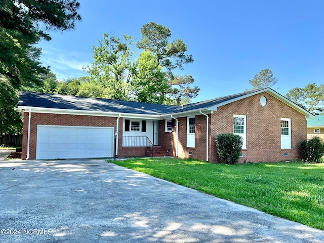 ranch-style home with a garage and a front lawn