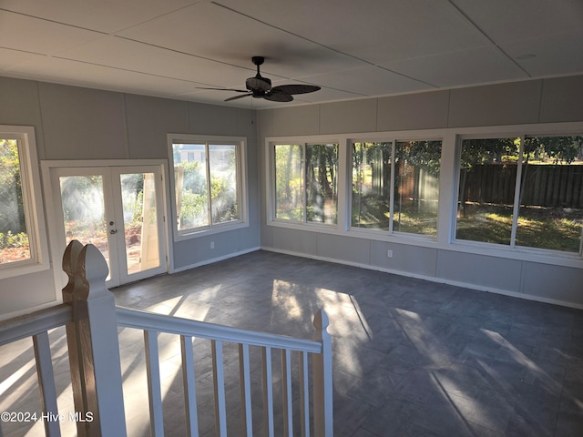 unfurnished sunroom featuring ceiling fan and french doors