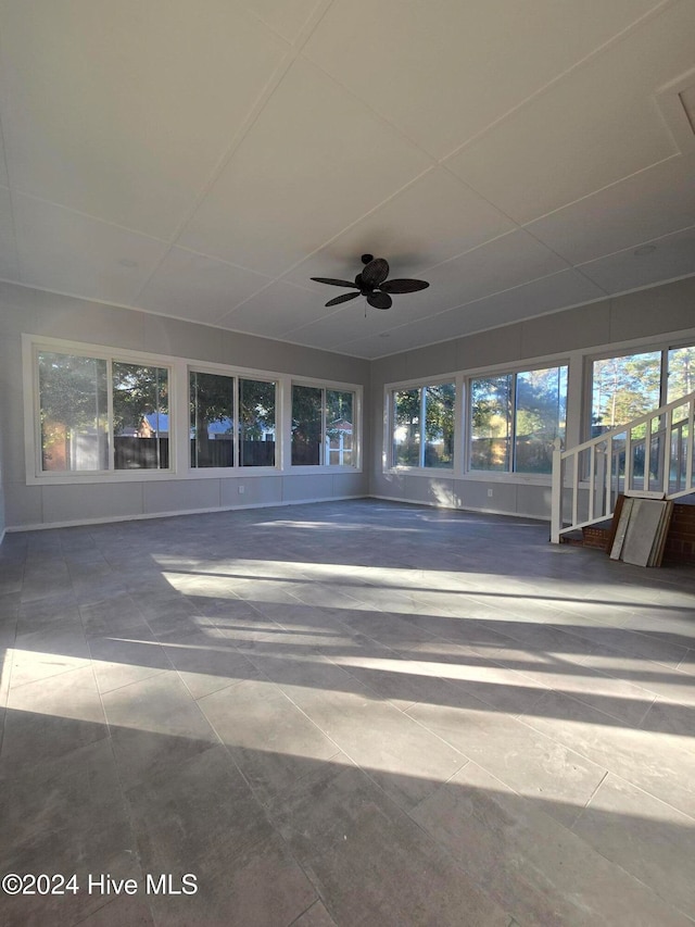 unfurnished sunroom featuring ceiling fan