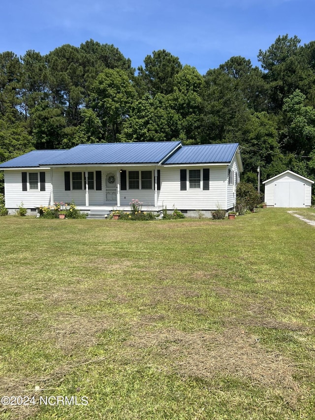 view of front of property with a front yard, a porch, and a shed