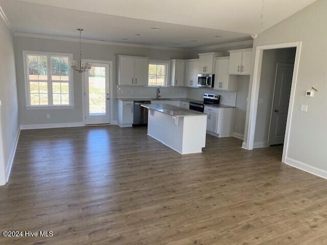 kitchen with appliances with stainless steel finishes, white cabinets, plenty of natural light, and a kitchen island