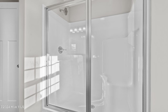 bathroom with a shower with door