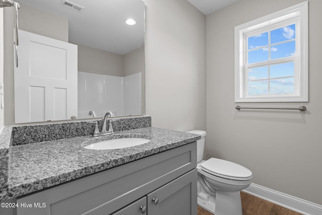 bathroom featuring wood-type flooring, vanity, and toilet