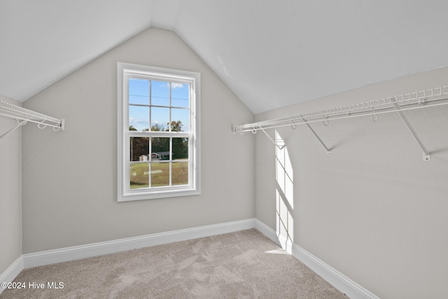 spacious closet with light colored carpet and lofted ceiling