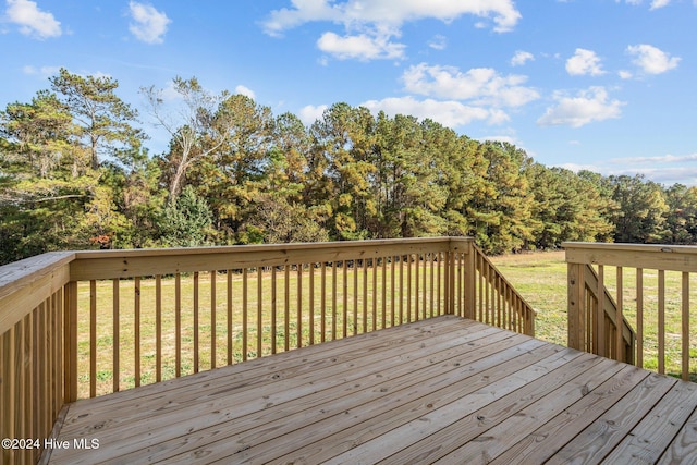 wooden deck featuring a lawn