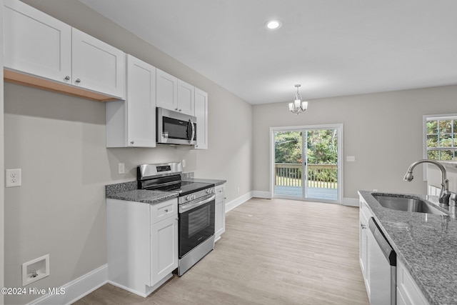 kitchen with stainless steel appliances, plenty of natural light, sink, and white cabinets