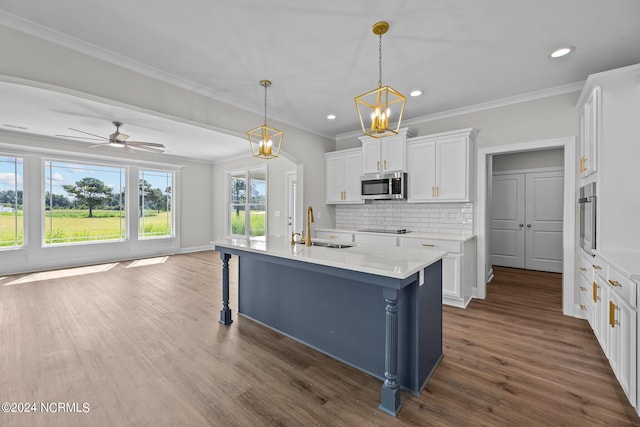 kitchen featuring ceiling fan with notable chandelier, dark hardwood / wood-style flooring, a center island with sink, sink, and white cabinets