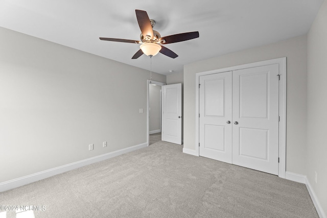 unfurnished bedroom with light colored carpet, ceiling fan, and a closet