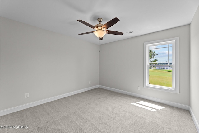 spare room with ceiling fan and light carpet