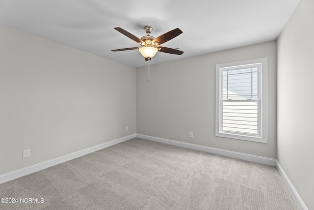 spare room featuring light colored carpet and ceiling fan