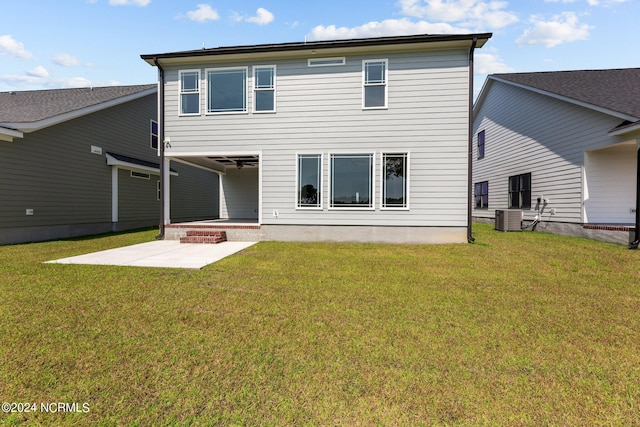 rear view of property featuring central AC, ceiling fan, a yard, and a patio