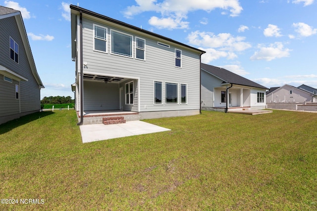 back of house with a patio area and a lawn