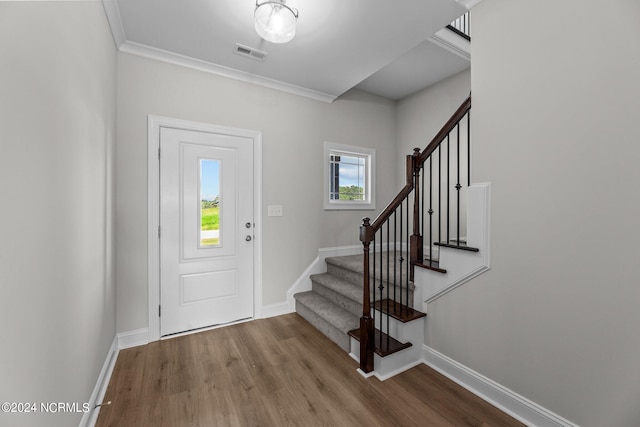 entrance foyer featuring hardwood / wood-style flooring and crown molding