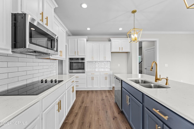 kitchen featuring pendant lighting, blue cabinets, stainless steel appliances, sink, and white cabinetry