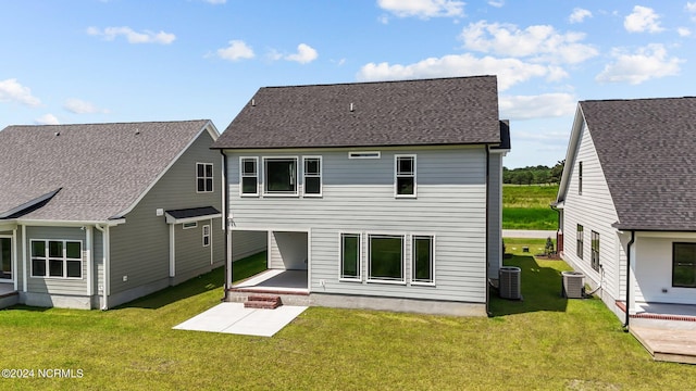 back of property with a yard, a patio area, and central air condition unit