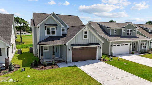 craftsman-style home featuring central air condition unit, a garage, and a front lawn