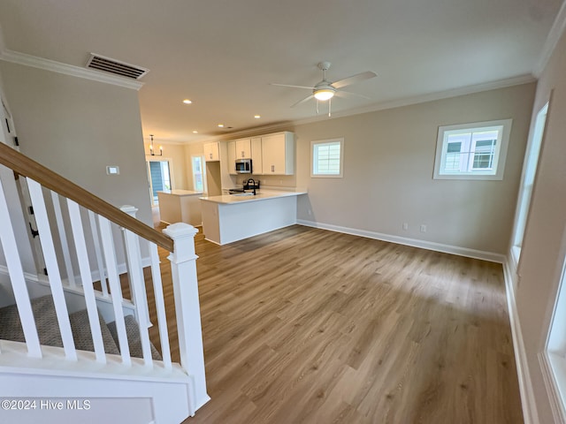 unfurnished living room featuring ceiling fan, light hardwood / wood-style flooring, and crown molding