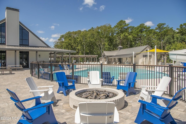 view of patio with an outdoor fire pit and a community pool