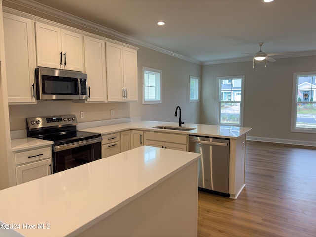 kitchen featuring sink, white cabinetry, appliances with stainless steel finishes, and kitchen peninsula