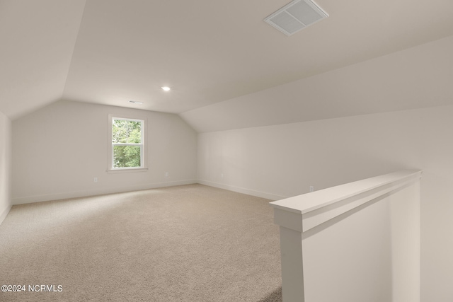 additional living space with carpet floors and vaulted ceiling