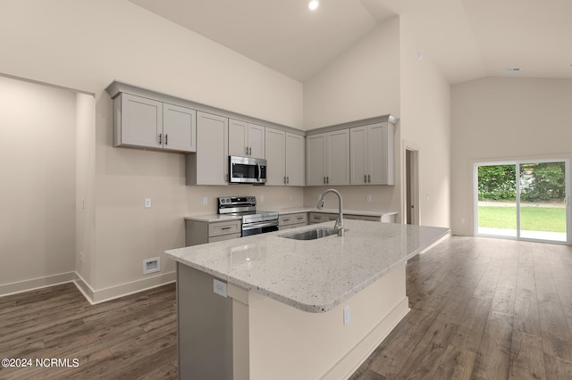 kitchen featuring dark wood-type flooring, stainless steel appliances, sink, a center island with sink, and gray cabinetry