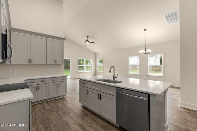 kitchen with ceiling fan with notable chandelier, sink, a kitchen island with sink, appliances with stainless steel finishes, and dark wood-type flooring