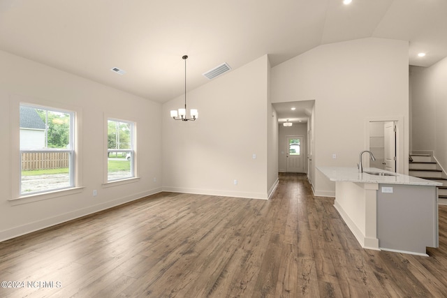 unfurnished living room featuring an inviting chandelier, sink, dark hardwood / wood-style floors, and lofted ceiling