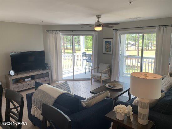 living room with a healthy amount of sunlight, tile patterned flooring, and ceiling fan