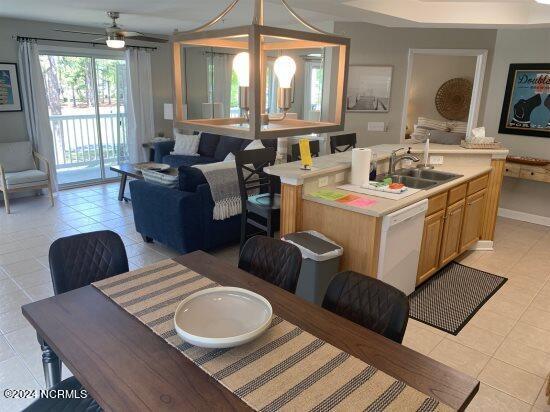 tiled dining room with ceiling fan and sink