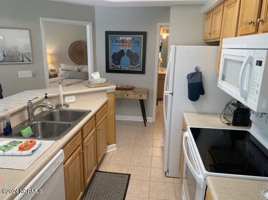 kitchen featuring sink, white appliances, and light tile floors