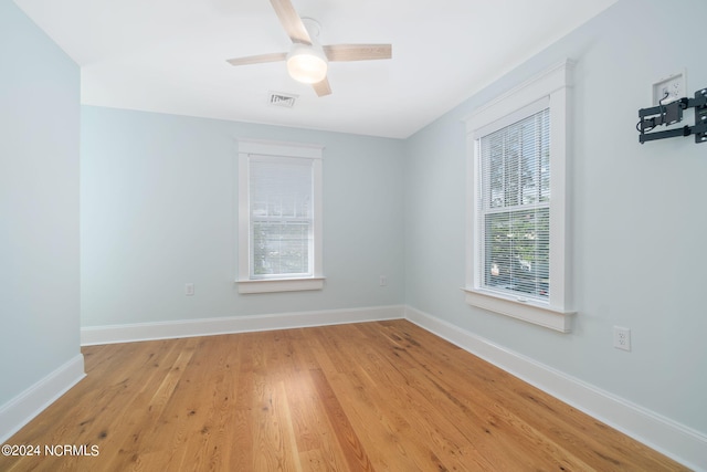 empty room with ceiling fan and light hardwood / wood-style floors