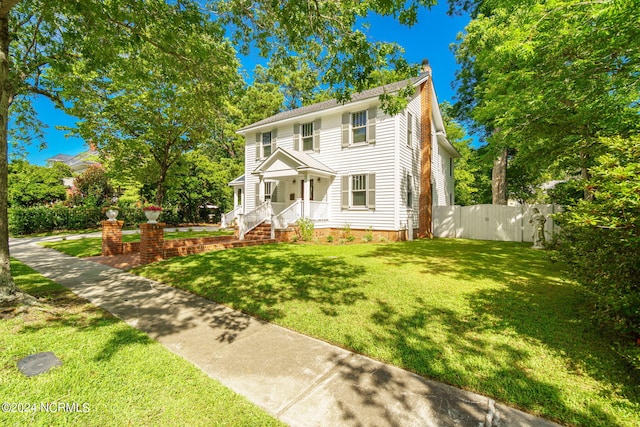 colonial-style house featuring a front lawn