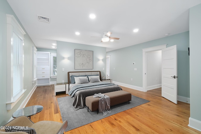 bedroom with multiple windows, ceiling fan, and light hardwood / wood-style floors