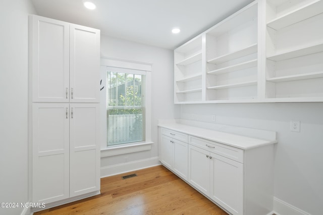 interior space with white cabinets and light hardwood / wood-style floors