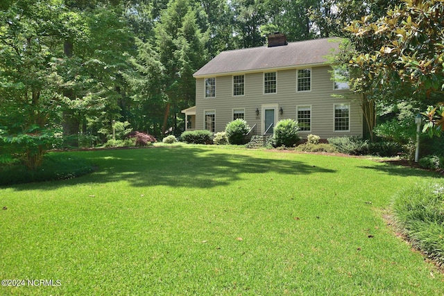 colonial inspired home with a front lawn