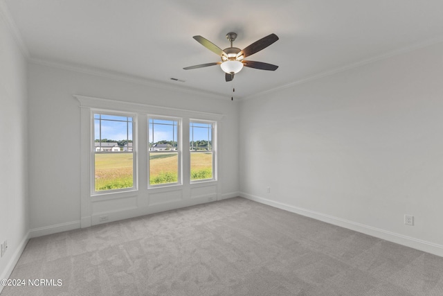 empty room with light colored carpet, ceiling fan, and ornamental molding