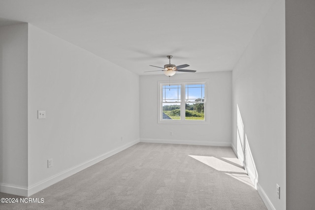 carpeted spare room with ceiling fan