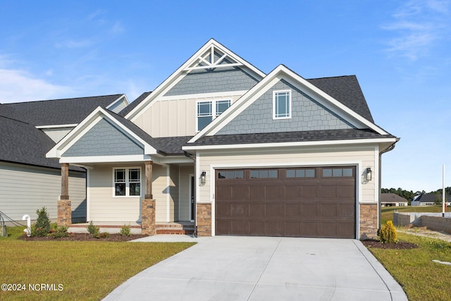 craftsman house with a garage and a front lawn