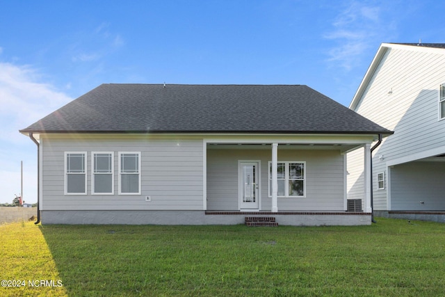 rear view of property featuring a lawn