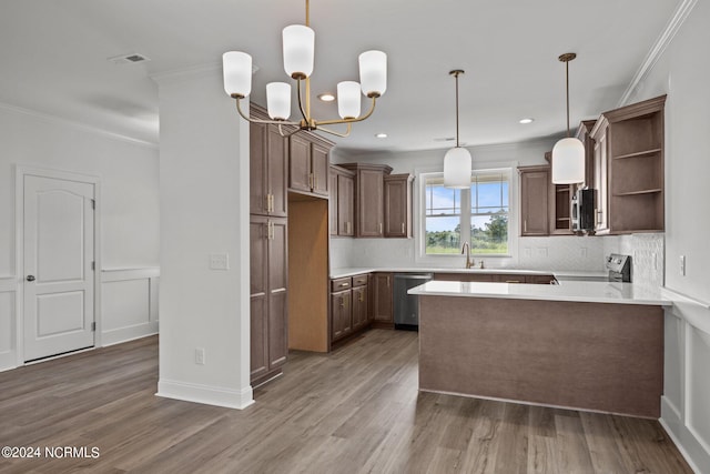 kitchen with appliances with stainless steel finishes, hardwood / wood-style flooring, a notable chandelier, and ornamental molding