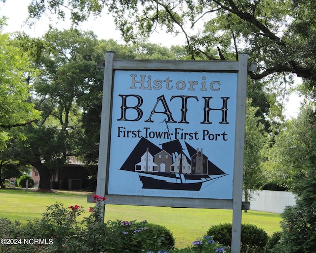 community sign with fence and a lawn