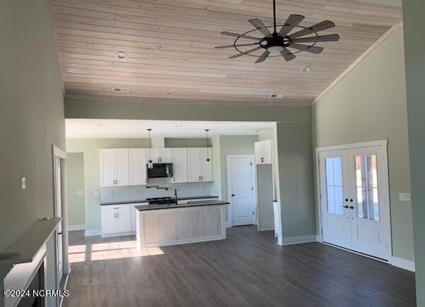 kitchen with white cabinetry, tasteful backsplash, dark hardwood / wood-style floors, wooden ceiling, and pendant lighting