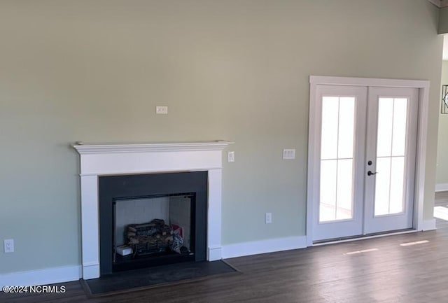 unfurnished living room with french doors, a fireplace, wood finished floors, and baseboards