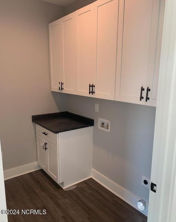 clothes washing area featuring cabinets, washer hookup, and dark wood-type flooring