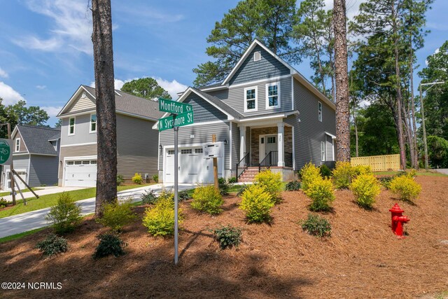 craftsman-style house featuring concrete driveway, fence, and an attached garage