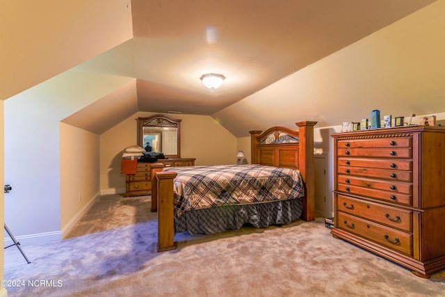 carpeted bedroom with vaulted ceiling and baseboards