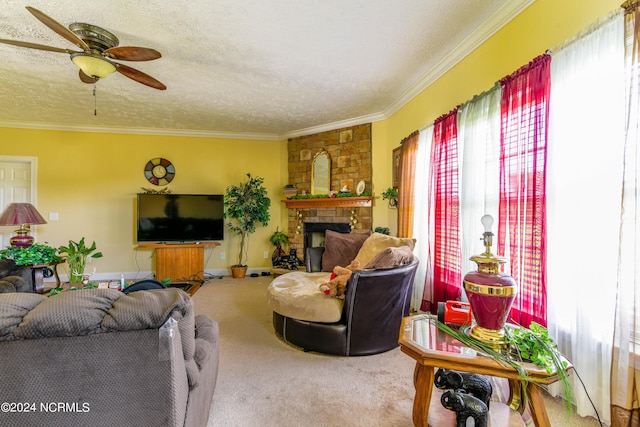 living area with a textured ceiling, a large fireplace, ornamental molding, and plenty of natural light