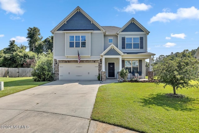 craftsman inspired home featuring a garage, a front lawn, and a porch