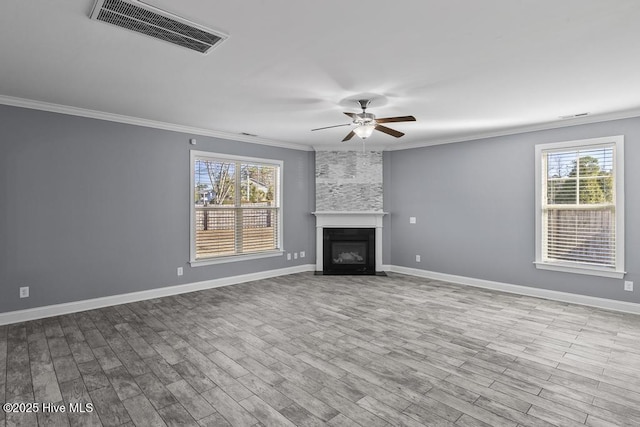 unfurnished living room with crown molding, light hardwood / wood-style floors, a large fireplace, and ceiling fan