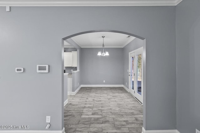 unfurnished dining area with ornamental molding, a notable chandelier, and light hardwood / wood-style flooring